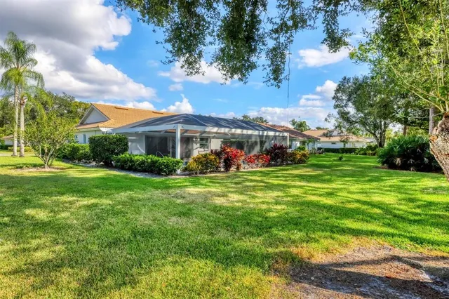 a view of a house with a big yard and large trees