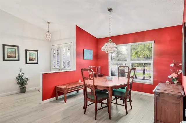 a dining room with furniture a chandelier and window
