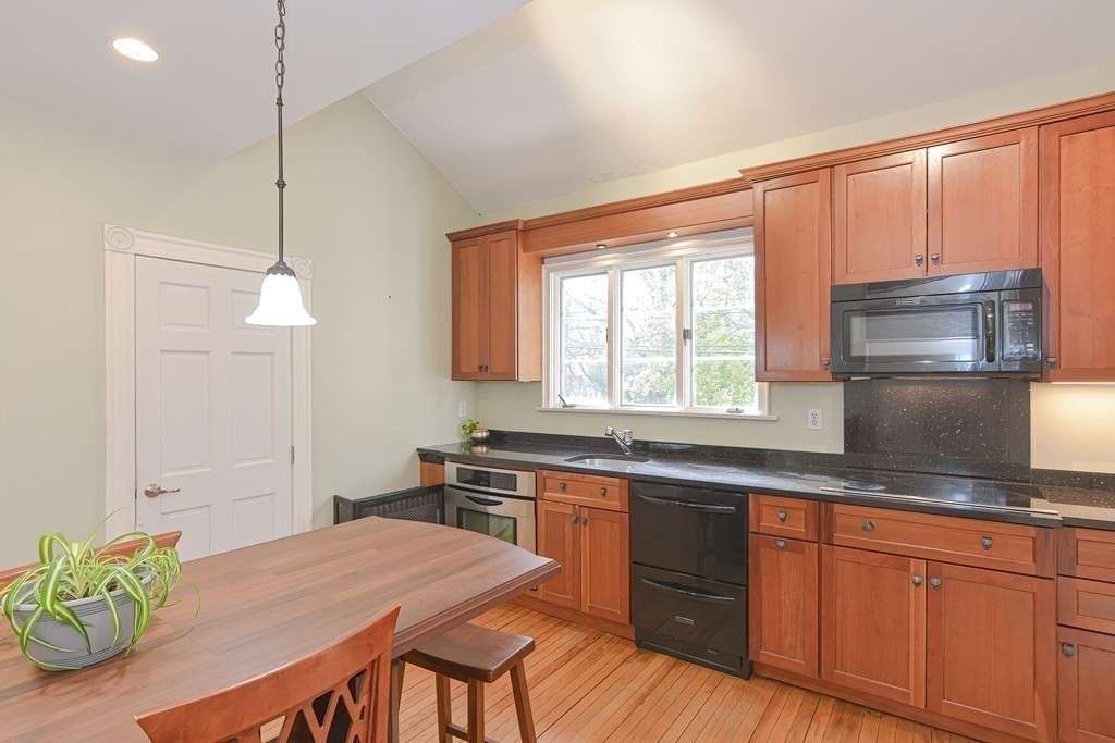 83 Eliot Street Natick, MA 01760 - Photo 10 of 42 a kitchen with stainless steel appliances granite countertop a sink a microwave cabinets and a wooden floor