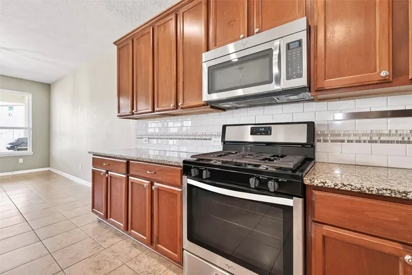 a kitchen with stainless steel appliances granite countertop a stove and a microwave