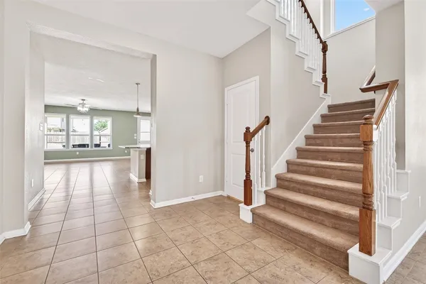 a view of an entryway with wooden floor and a kitchen