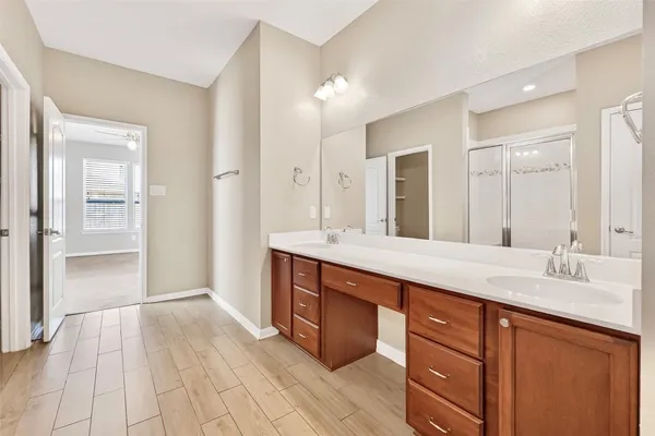 a spacious bathroom with a shower sink and mirror