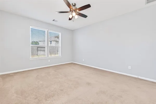an empty room with windows and fan