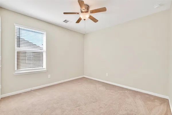 an empty room with a window and a fan