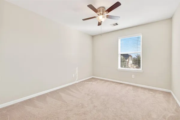 an empty room with a window and a fan