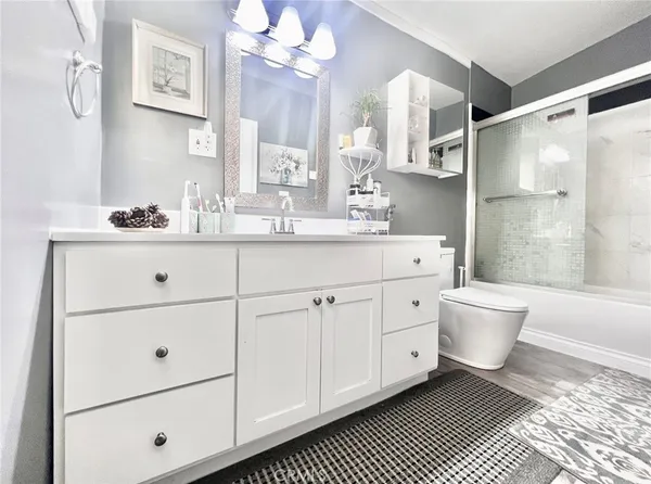 a spacious bathroom with a double vanity sink a toilet a mirror and shower