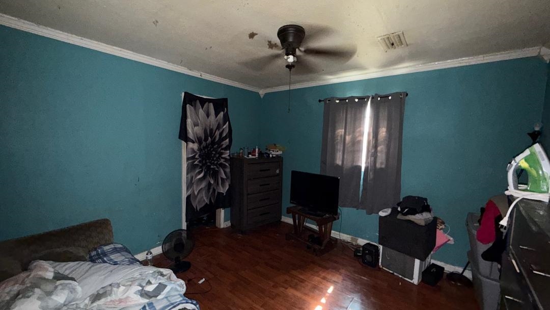 1507 Rich Road West Memphis, AR 72301 - Photo 9 of 12 Bedroom featuring dark wood-style flooring, ceiling fan, and ornamental molding