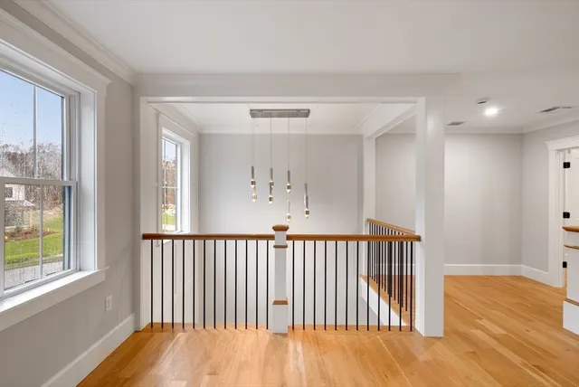 a view of a hallway with a window and wooden floor