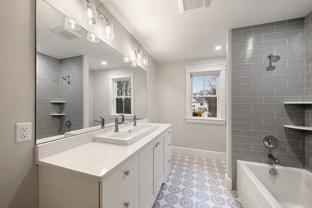 a bathroom with a sink a large mirror and a bathtub