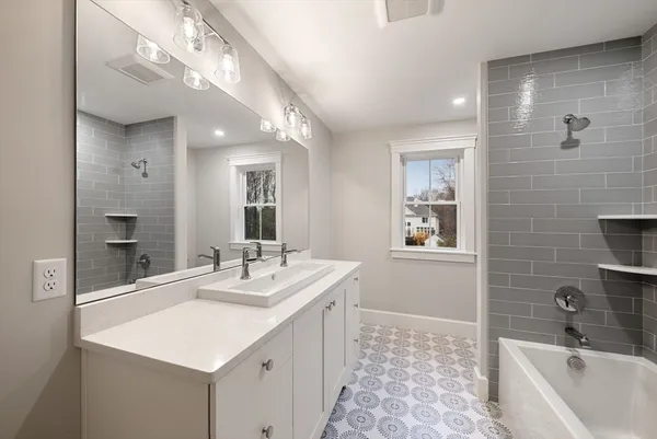 a bathroom with a sink a large mirror and a bathtub