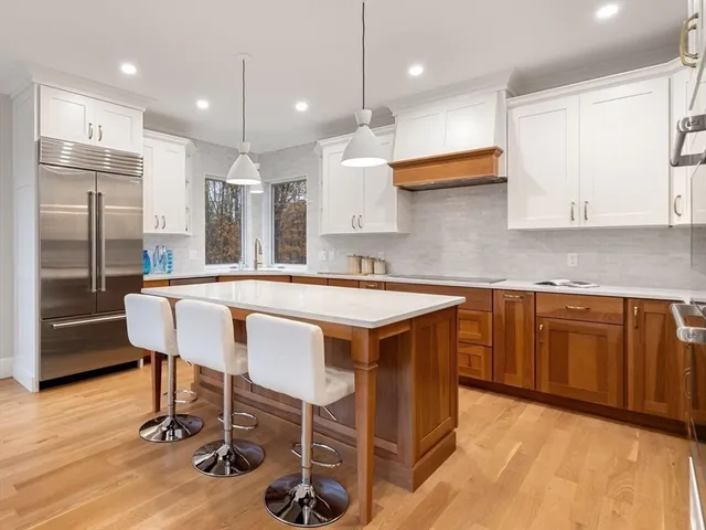 a kitchen with kitchen island granite countertop a sink and a refrigerator