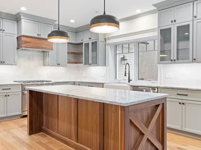 a kitchen with stainless steel appliances granite countertop a sink a stove and a refrigerator