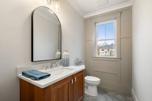 a bathroom with a toilet sink vanity and mirror