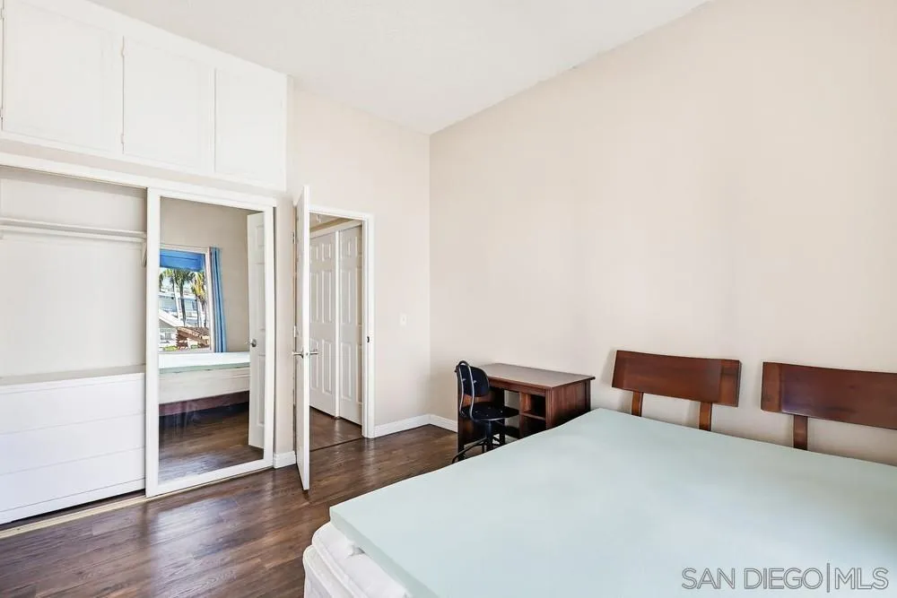 8324 Regents Road, Unit 2E San Diego, CA 92122 - Photo 25 of 31 a bedroom with a bed and wooden floor