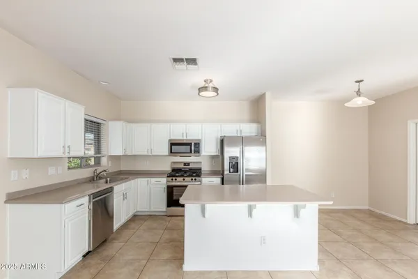 a large kitchen with cabinets and stainless steel appliances