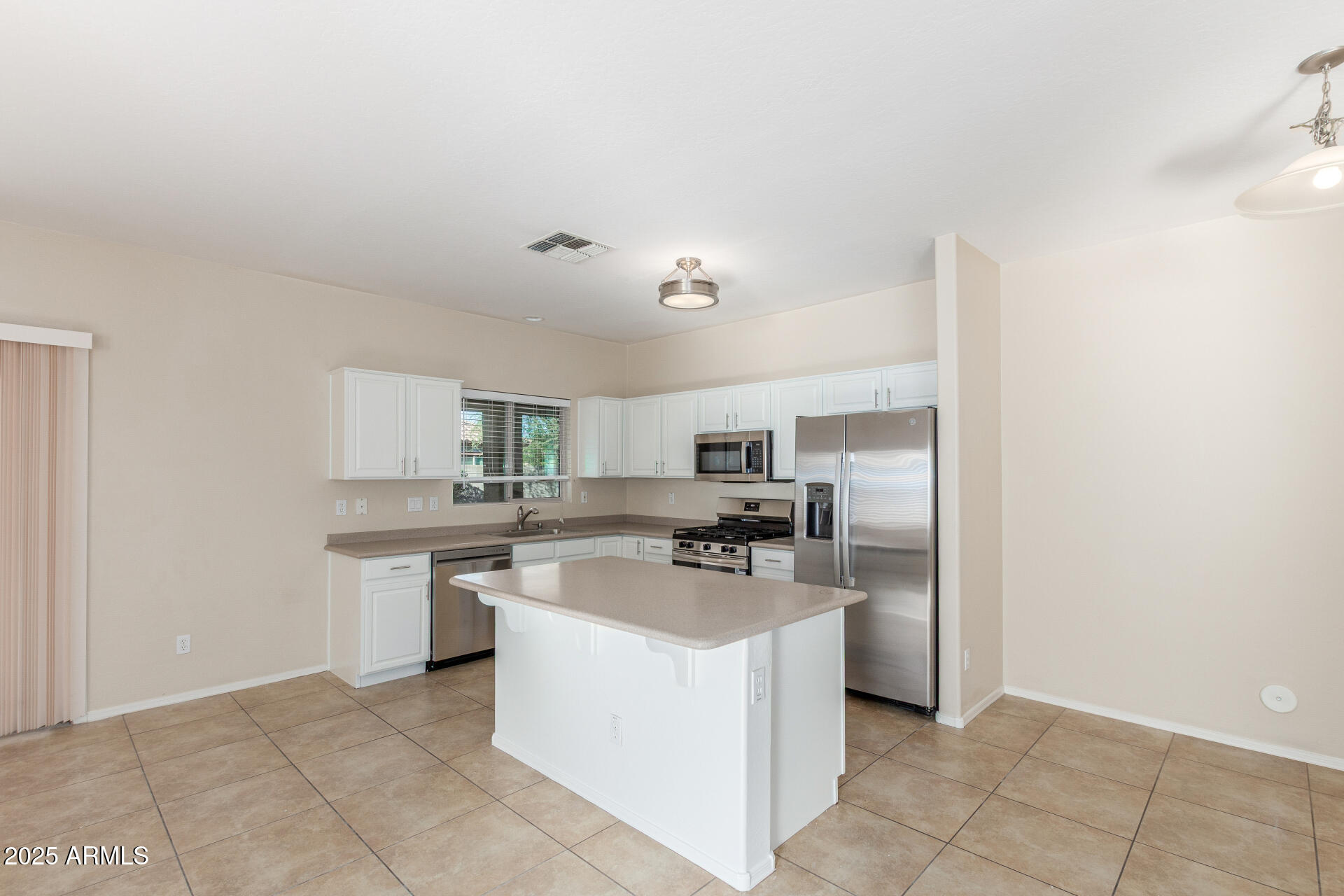 4480 South Marble Street Gilbert, AZ 85297 - Photo 9 of 26 a kitchen with a sink a stove top oven and cabinets