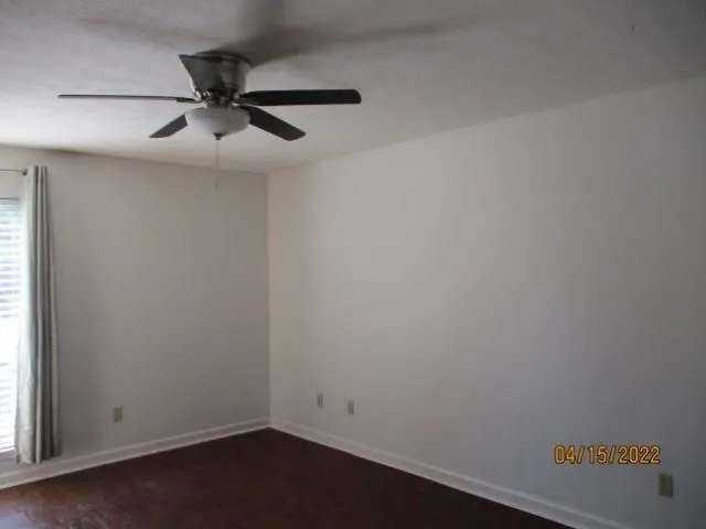 an empty room with a window and a fan