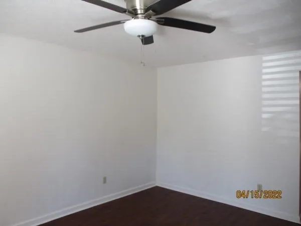 an empty room with a window and a fan