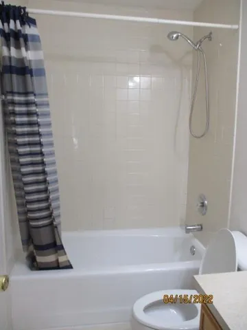 a bathroom with a shower a toilet and a shower