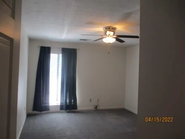 an empty room with closet and chandelier fan