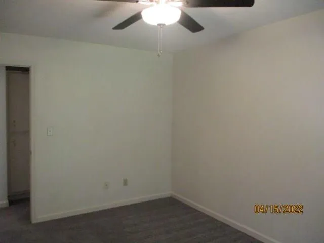 an empty room with a ceiling fan and a window