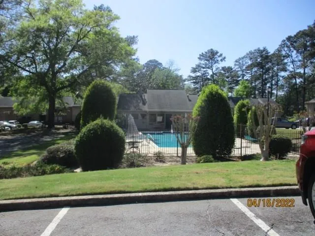 a view of house with a yard and potted plants