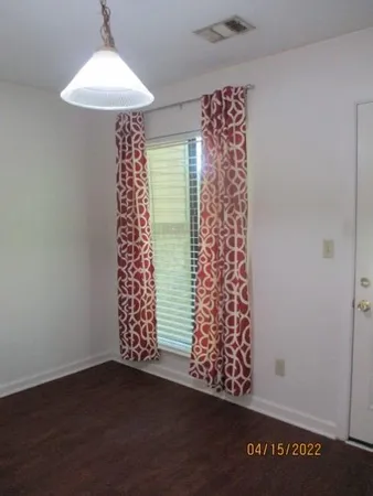 an empty room with a window and wooden floor