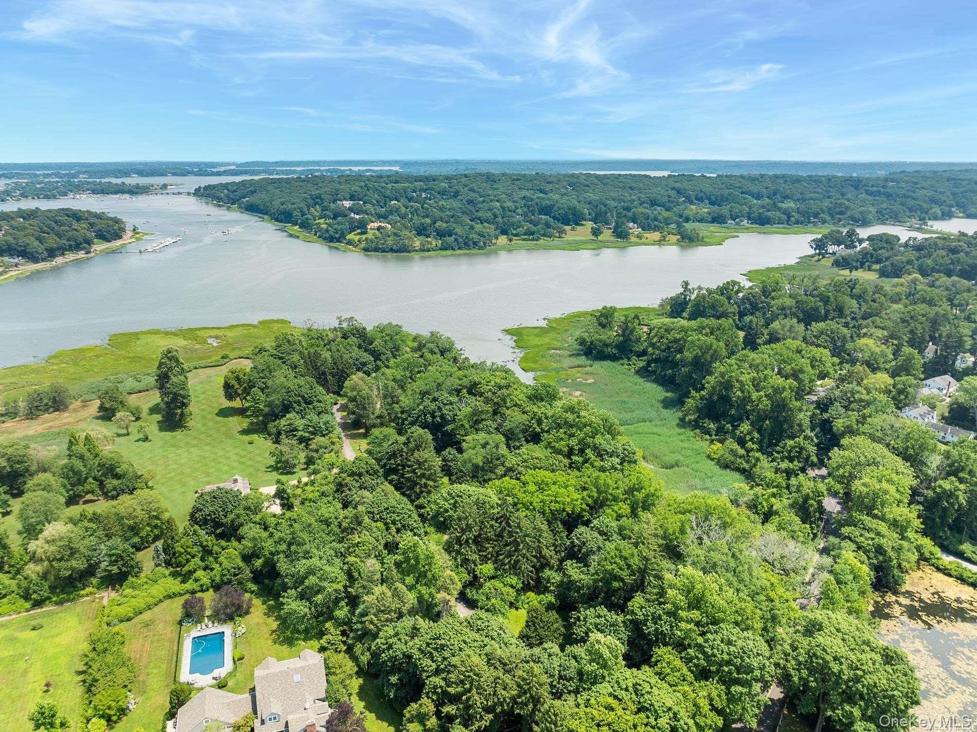 31 Factory Pond Road Locust Valley, NY 11560 - Photo 2 of 14 an aerial view of green landscape with trees houses and lake view