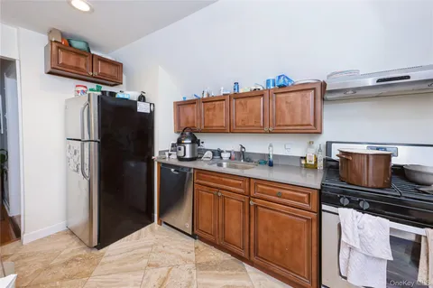 a kitchen with stainless steel appliances granite countertop a refrigerator stove and sink