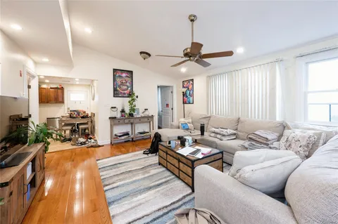 a living room with furniture kitchen view and a large window