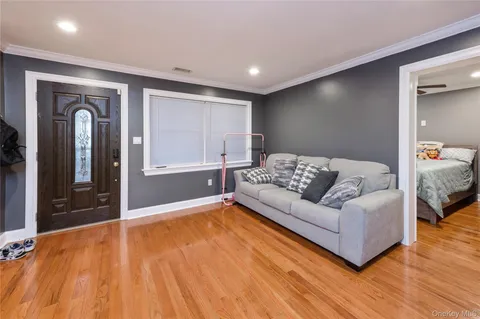 a living room with a bed furniture and wooden floor