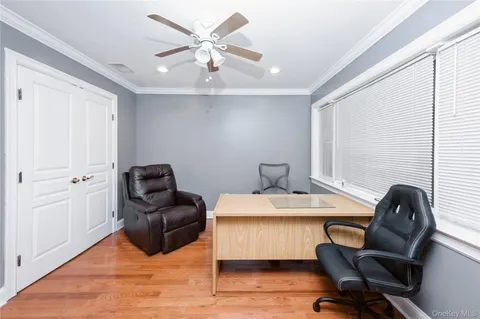 a view of a workspace with furniture and a window