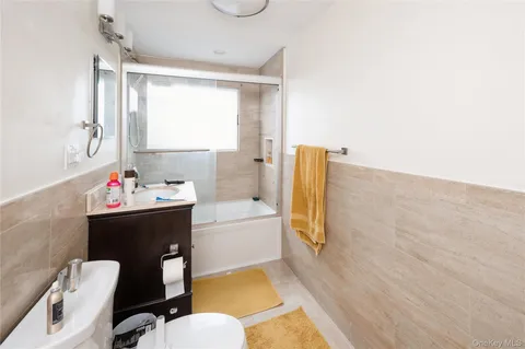 a bathroom with a tub sink and mirror