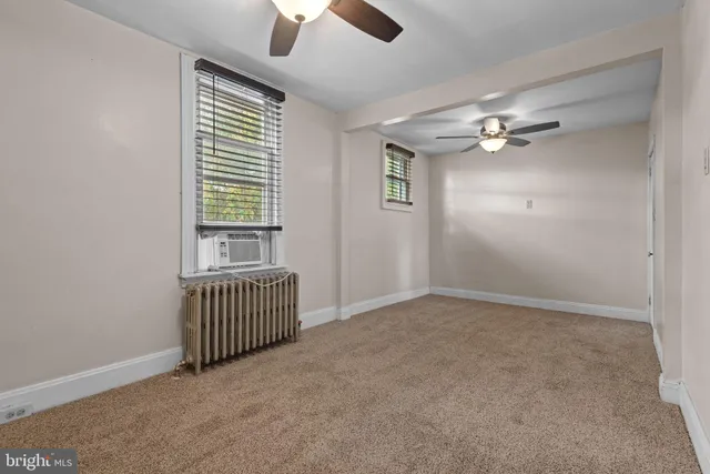 an empty room with chandelier fan