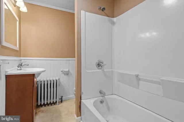 a bathroom with a tub sink and mirror