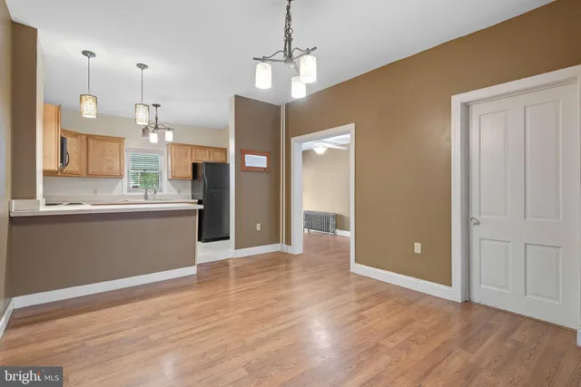 a view of large kitchen with granite countertop cabinets and wooden floor