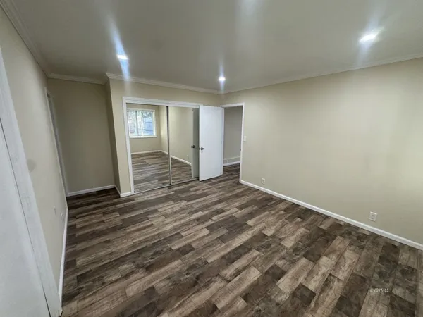 an empty room with wooden floor and window