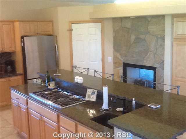 16835 Roller Coaster Road Colorado Springs, CO 80921 - Photo 12 of 25 Kitchen has a double side gas fireplace-This home is bright and open!