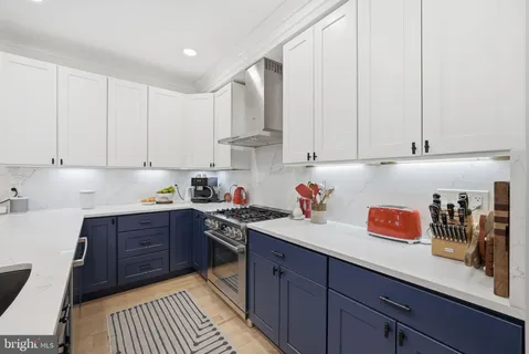a kitchen with stainless steel appliances granite countertop a sink dishwasher stove and cabinets with wooden floor