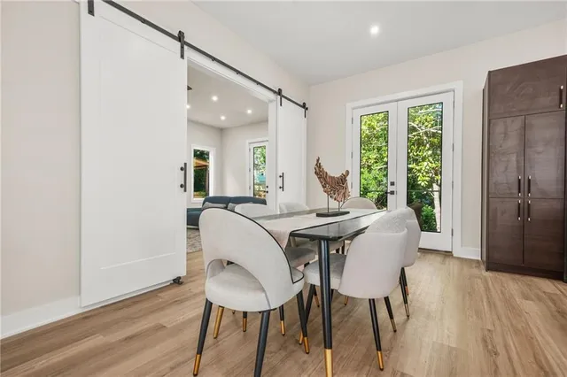 a kitchen with kitchen island granite countertop wooden floors and white cabinets