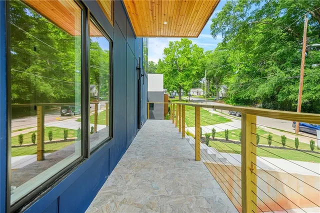 a living room with furniture kitchen view and a wooden floor