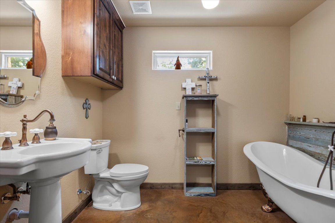 7835 Berger Road Schulenburg, TX 78956 - Photo 19 of 40 Bathroom with a freestanding tub, concrete flooring, and a textured wall