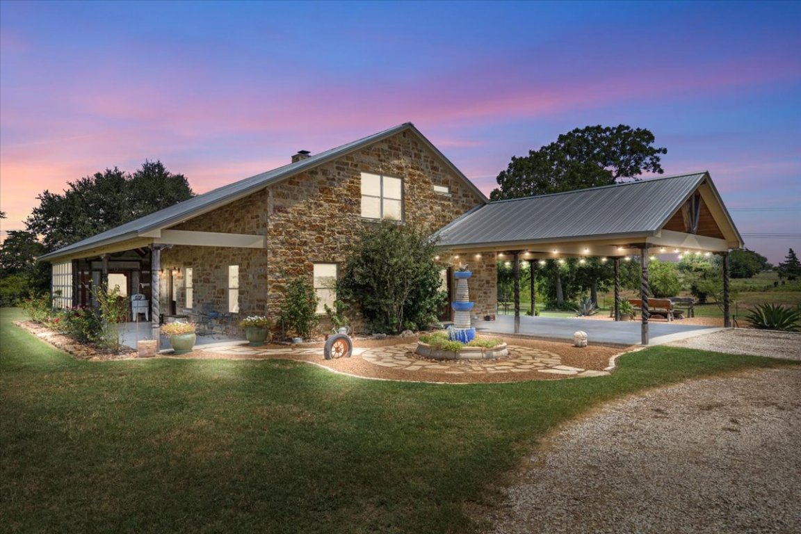 7835 Berger Road Schulenburg, TX 78956 - Photo 2 of 40 Front of house at dusk with a carport, a yard, and stone siding