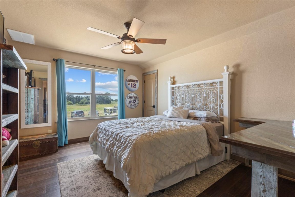 7835 Berger Road Schulenburg, TX 78956 - Photo 21 of 40 Bedroom with wood finished floors, a textured ceiling, and a ceiling fan