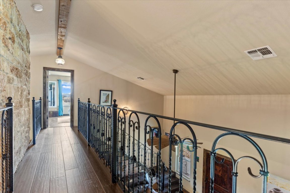 7835 Berger Road Schulenburg, TX 78956 - Photo 22 of 40 Catwalk between upstairs bedroom with bamboo flooring and metal railings