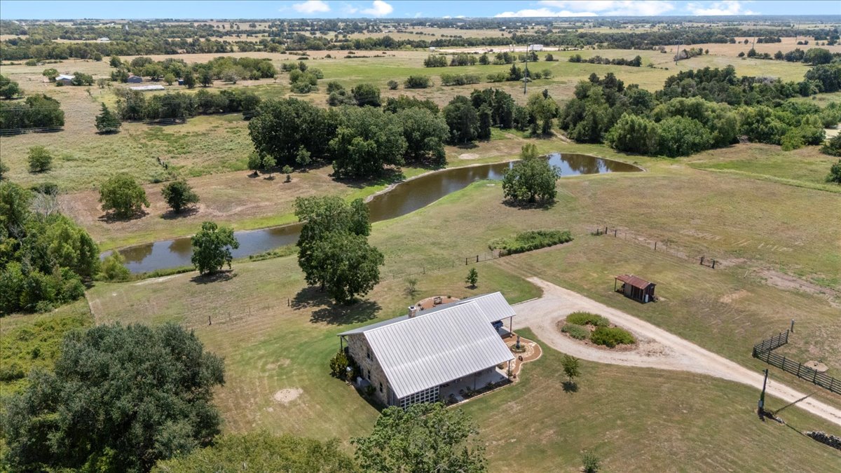 7835 Berger Road Schulenburg, TX 78956 - Photo 3 of 40 Overview of rural landscape showing the pond on the property. The landscaped area in the center of the the driveway features native texas plants and is where the 500-gallon propane tank is buried