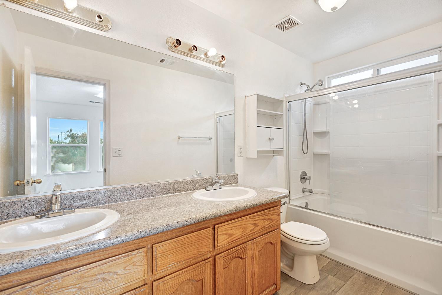 2061 Seventh Street Fresno, CA 93702 - Photo 16 of 38 a bathroom with a granite countertop sink toilet and shower