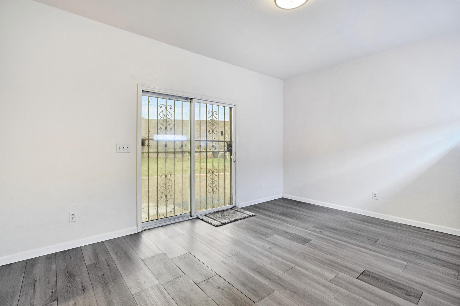 2061 Seventh Street Fresno, CA 93702 - Photo 22 of 38 an empty room with wooden floor and windows