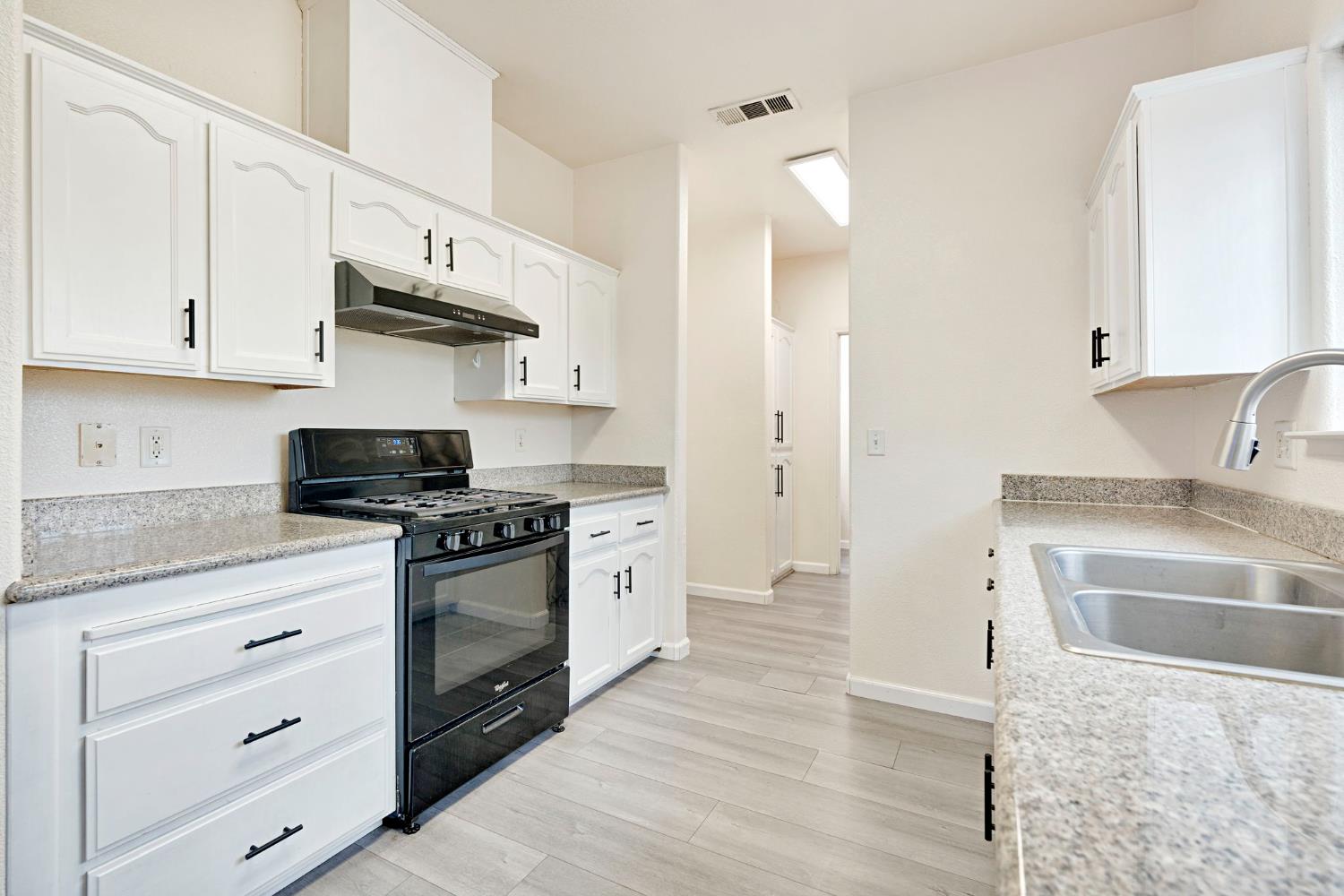 2061 Seventh Street Fresno, CA 93702 - Photo 8 of 38 a kitchen with stainless steel appliances granite countertop a sink stove and refrigerator