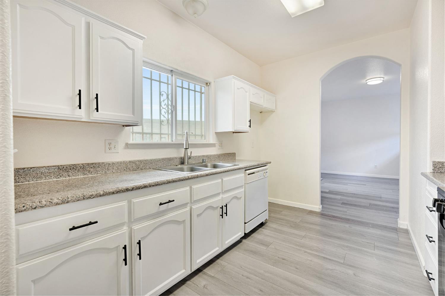2061 Seventh Street Fresno, CA 93702 - Photo 9 of 38 a kitchen with granite countertop white cabinets and a sink